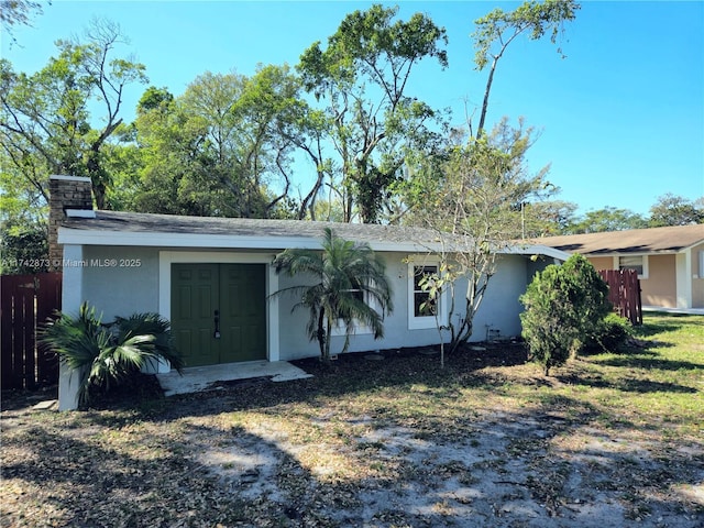 view of front of property with stucco siding and fence