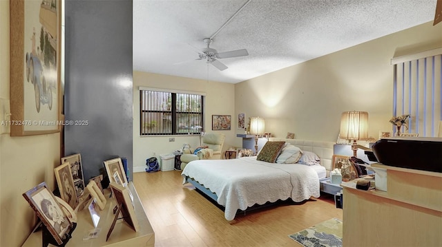 bedroom with a textured ceiling, a ceiling fan, and wood finished floors