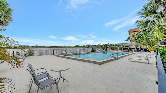 pool with a patio and fence