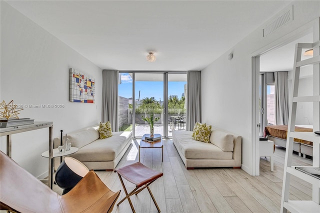 living room with expansive windows and light wood-type flooring