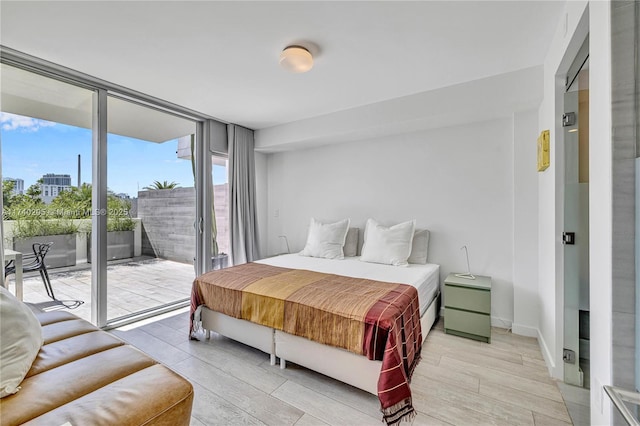 bedroom with light hardwood / wood-style flooring, access to outside, and floor to ceiling windows