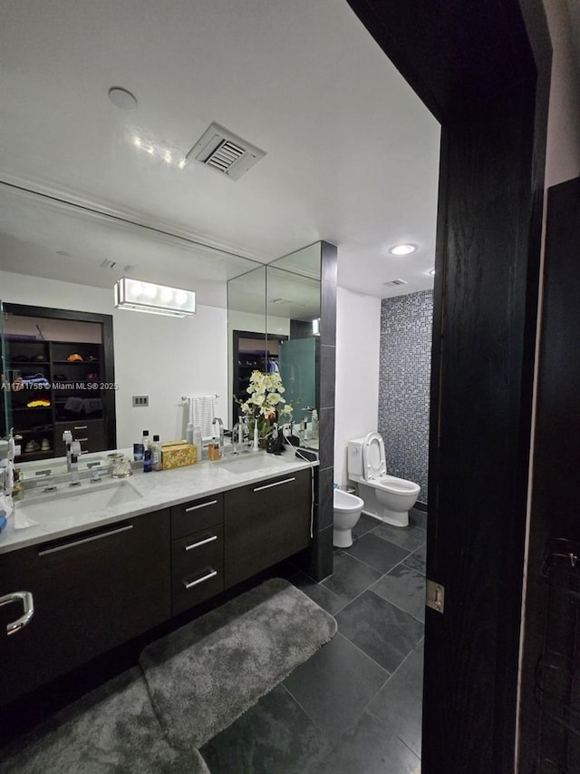 bathroom with a bidet, vanity, and toilet