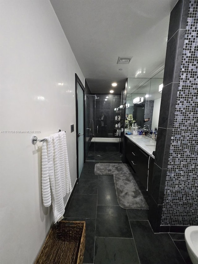 bathroom featuring vanity, tile patterned flooring, and a shower with door