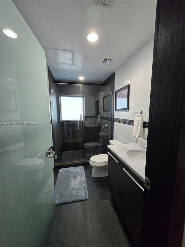 bathroom with vanity, toilet, and a shower with shower door