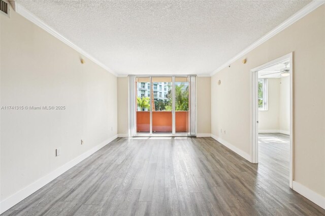 2000 N Bayshore Dr Unit 304, Miami, FL 33137 - unfurnished room with healthy amount of natural light, ornamental molding, a textured ceiling, wood finished floors, and baseboards