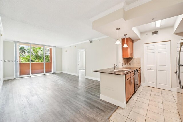 2000 N Bayshore Dr Unit 304, Miami, FL 33137 - kitchen featuring a sink, ornamental molding, open floor plan, light wood-type flooring, and brown cabinets