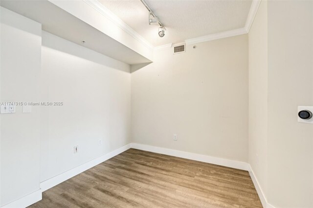2000 N Bayshore Dr Unit 304, Miami, FL 33137 - unfurnished room featuring track lighting, crown molding, wood finished floors, baseboards, and a textured ceiling