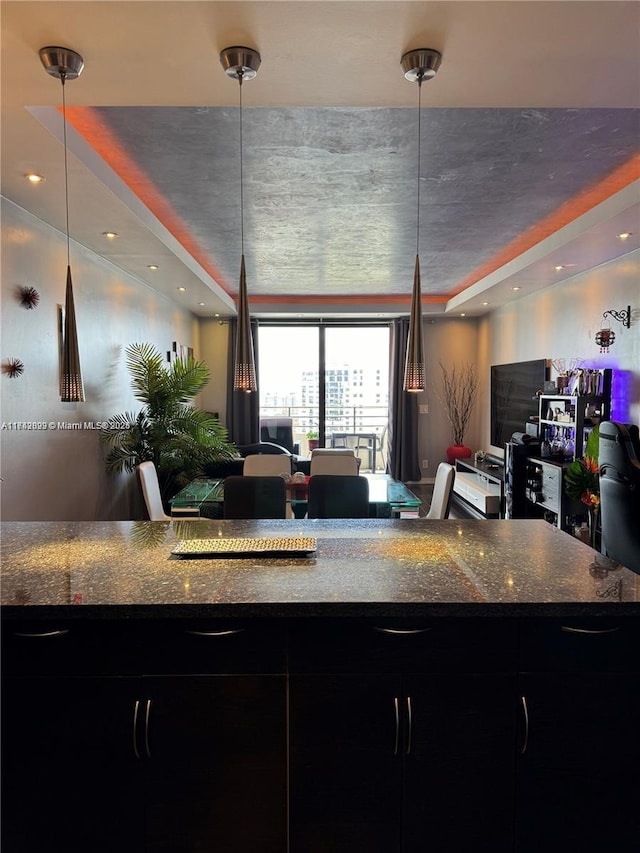 kitchen with hanging light fixtures and dark stone countertops