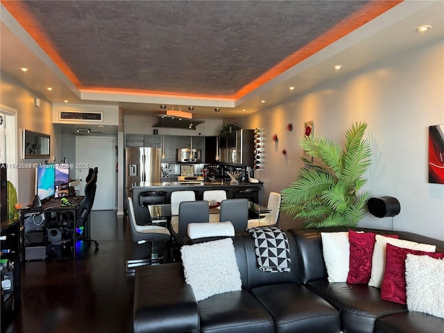 living room with a raised ceiling, dark wood-type flooring, and a textured ceiling