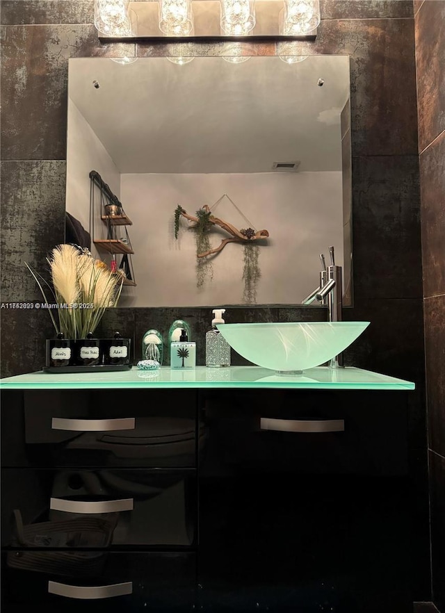 bathroom with vanity and tile walls