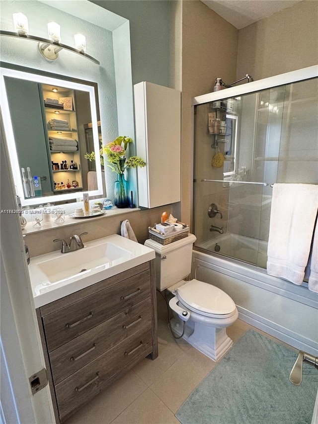 full bathroom featuring enclosed tub / shower combo, tile patterned floors, toilet, and vanity