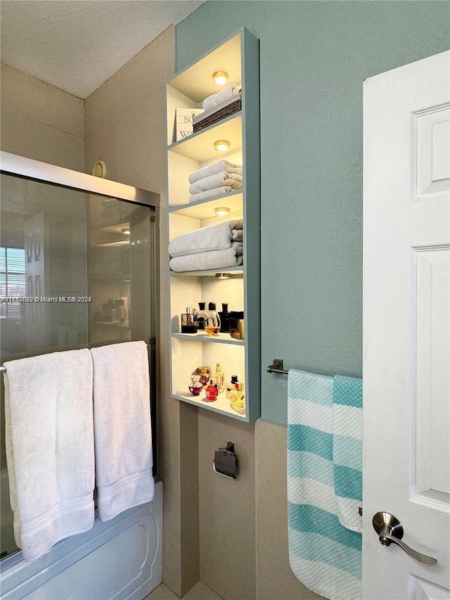 bathroom featuring a shower with shower door