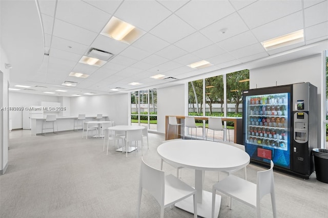 dining room featuring a drop ceiling and light carpet