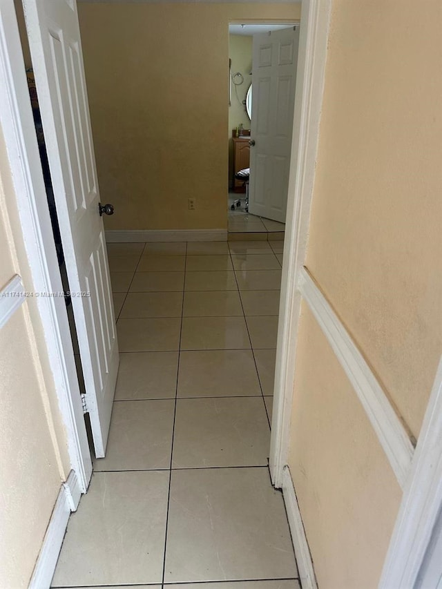 hallway with light tile patterned flooring and a baseboard heating unit