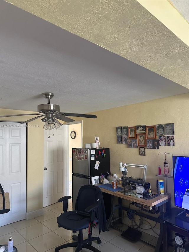 tiled office space with ceiling fan and a textured ceiling