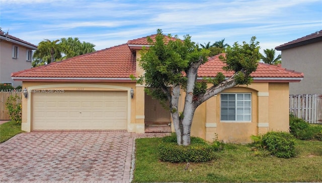 12239 SW 140th St, Miami, FL 33186 - mediterranean / spanish-style home with a tiled roof, decorative driveway, stucco siding, fence, and an attached garage