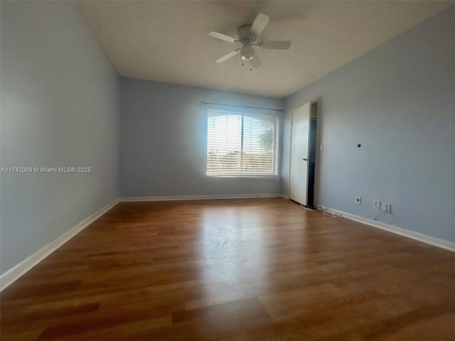 empty room with ceiling fan, baseboards, and wood finished floors