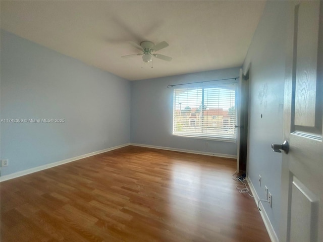 unfurnished room featuring ceiling fan, baseboards, and wood finished floors