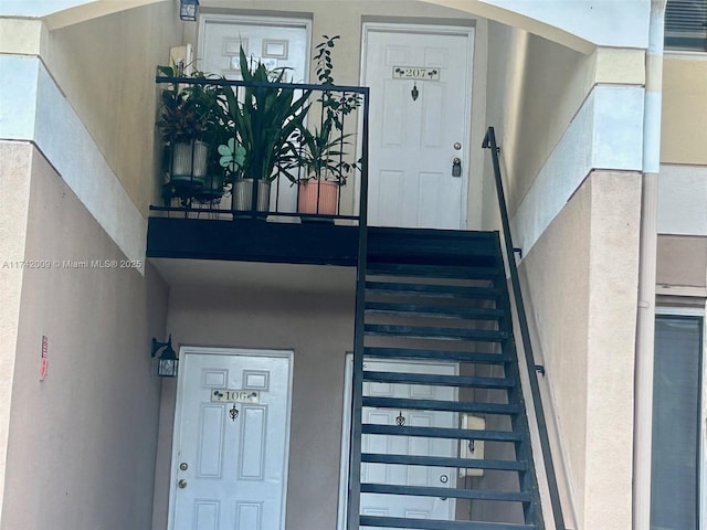 entrance to property featuring stucco siding