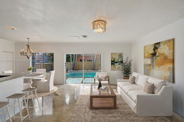 living room with crown molding, an inviting chandelier, and a textured ceiling