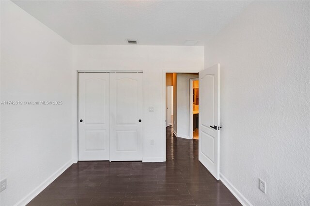 empty room featuring dark hardwood / wood-style floors and a textured ceiling