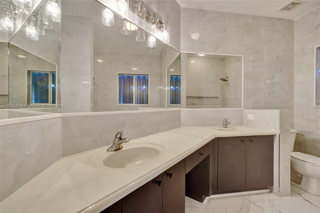 bathroom featuring vanity, toilet, and tile walls