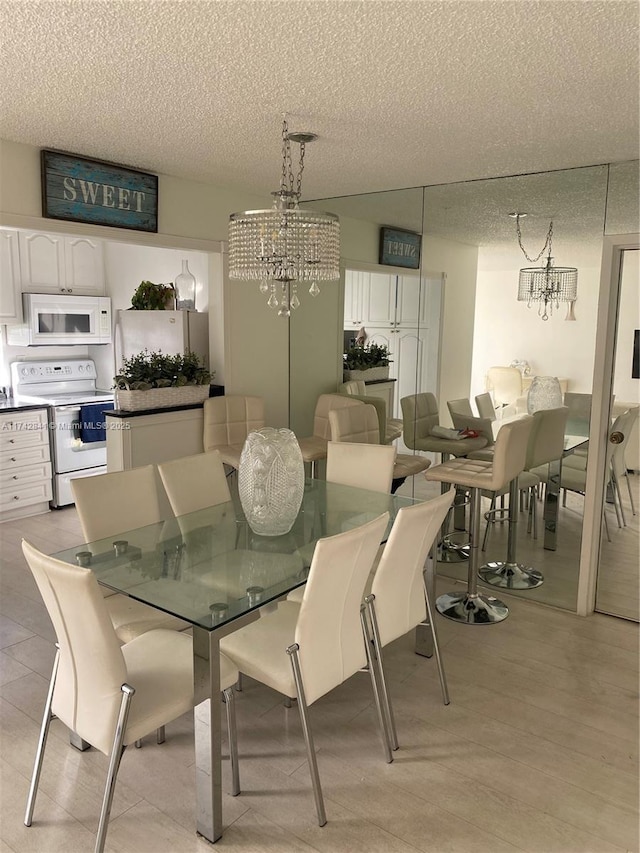 dining room with a chandelier and a textured ceiling