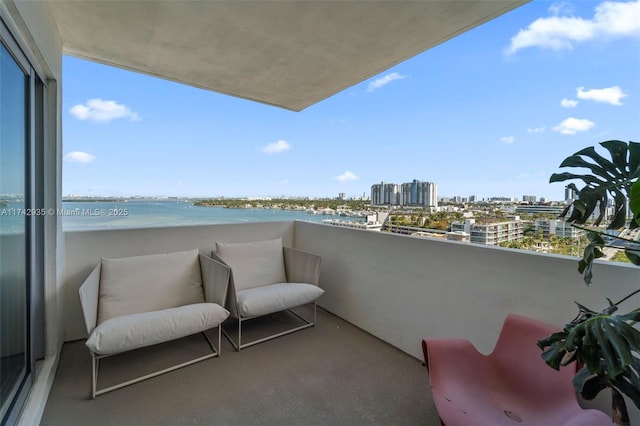 balcony featuring a water view and a view of the beach