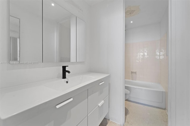 full bathroom featuring tiled shower / bath, vanity, toilet, and tile patterned flooring