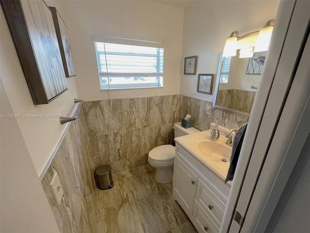 bathroom featuring vanity, tile walls, and toilet