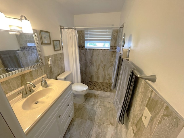 bathroom with vanity, curtained shower, tile walls, and toilet