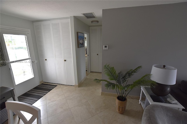 interior space with light tile patterned flooring and a textured ceiling