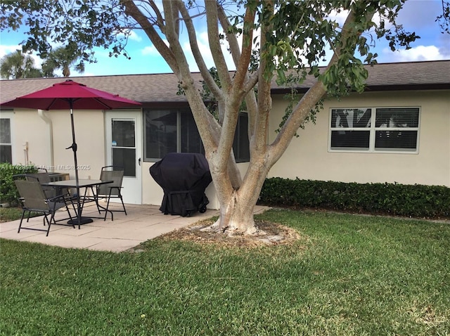 back of property with a yard and a patio