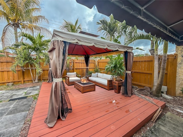 wooden deck featuring a gazebo and an outdoor living space with a fire pit