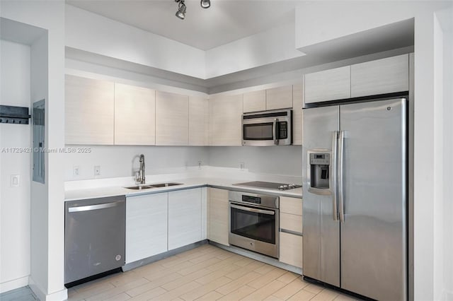 kitchen featuring sink, light hardwood / wood-style flooring, track lighting, electric panel, and stainless steel appliances