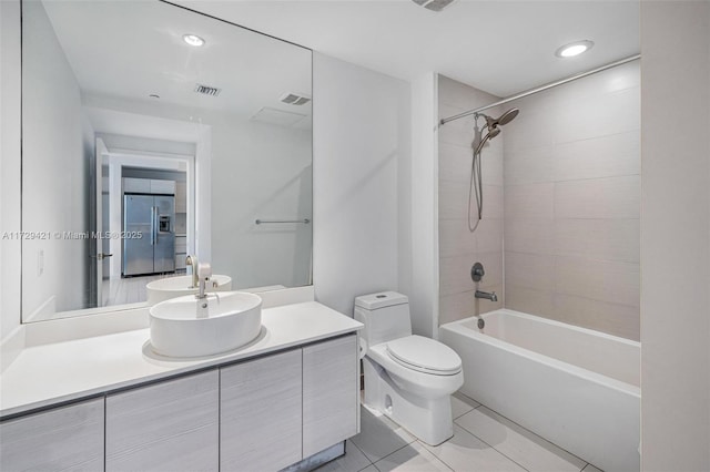 full bathroom with vanity, tiled shower / bath, tile patterned floors, and toilet