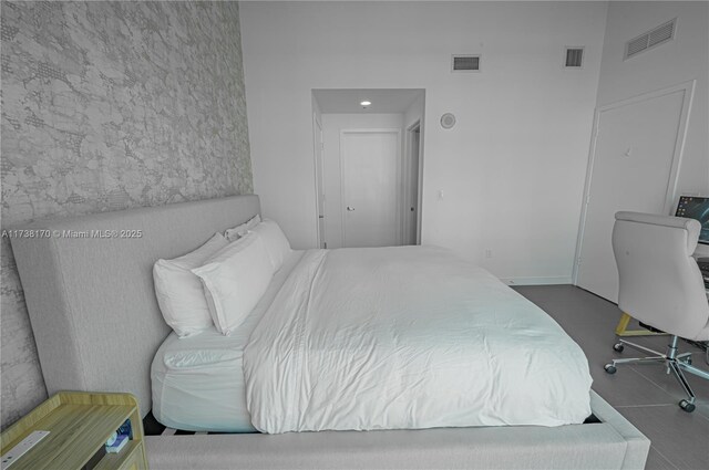 bedroom with visible vents and a towering ceiling