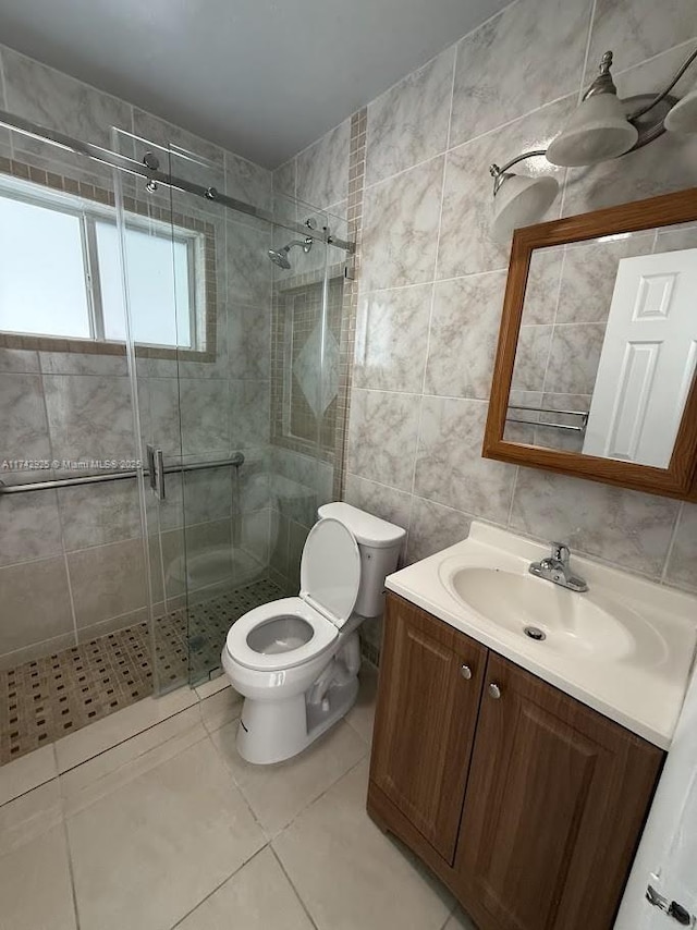 bathroom with tile patterned floors, toilet, an enclosed shower, tile walls, and vanity