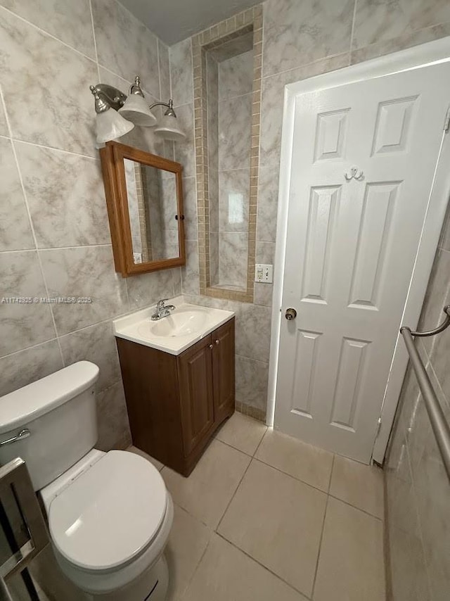 bathroom featuring vanity, tile walls, tile patterned floors, and toilet