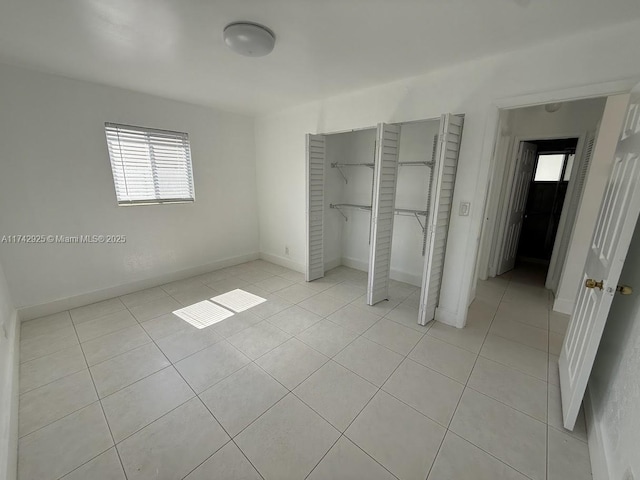 unfurnished bedroom featuring light tile patterned flooring and a closet