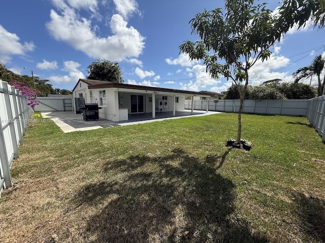 back of property with a yard and a patio