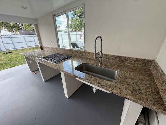 kitchen with stone counters, sink, and a kitchen breakfast bar