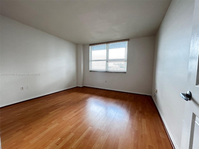 unfurnished room with hardwood / wood-style flooring