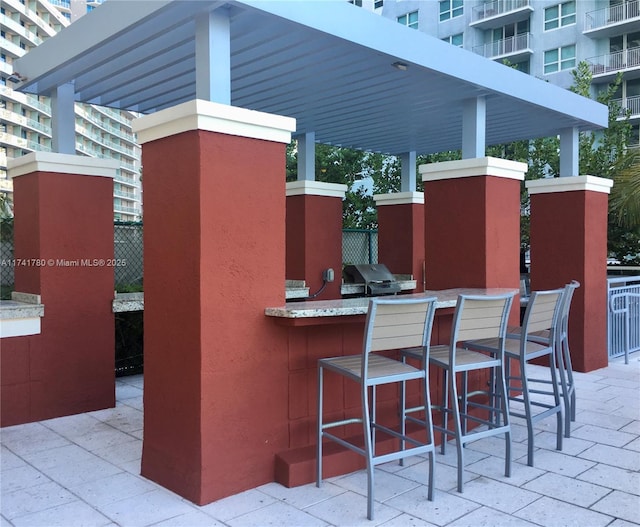 view of patio featuring a bar, grilling area, and an outdoor kitchen