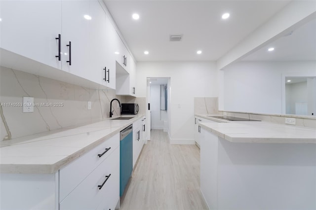 kitchen featuring sink, backsplash, white cabinets, stainless steel dishwasher, and light wood-type flooring