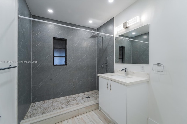 bathroom featuring vanity and tiled shower