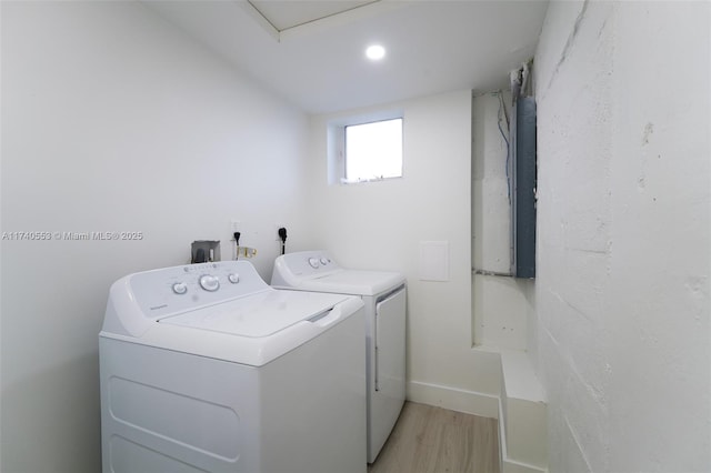 laundry area featuring washing machine and dryer and light wood-type flooring