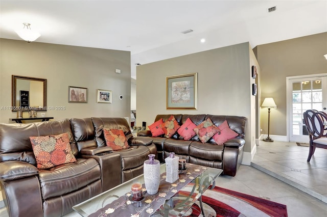 living room featuring vaulted ceiling and light tile patterned floors