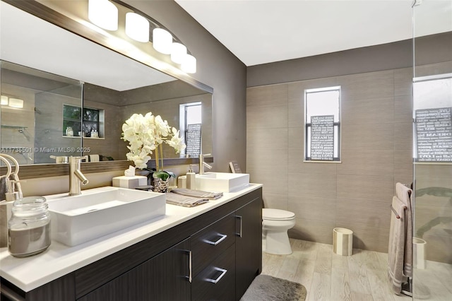 bathroom featuring tile walls, vanity, hardwood / wood-style floors, and toilet