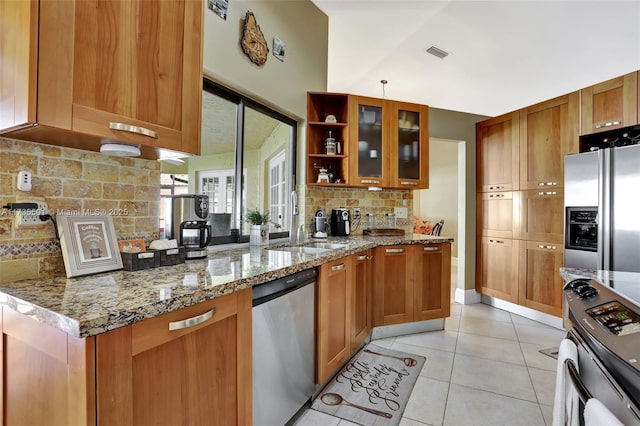 kitchen with appliances with stainless steel finishes, tasteful backsplash, sink, light tile patterned floors, and light stone counters